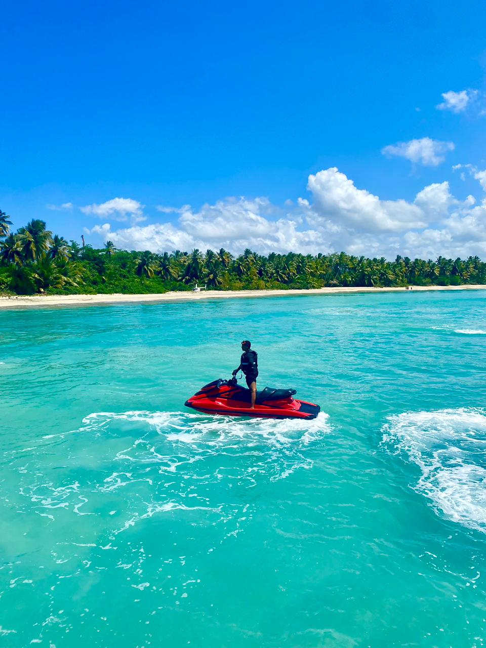 Jet ski rojo en la playa de Miches con palmeras